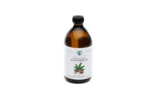 Foto van een fles biologische Prana Esencia castorolie met wit etiket, op een heldere achtergrond. Het etiket bevat de tekst '100% Biologisch, koudgeperst en hexaanvrij' en een afbeelding van een Ricinus Communis plant.